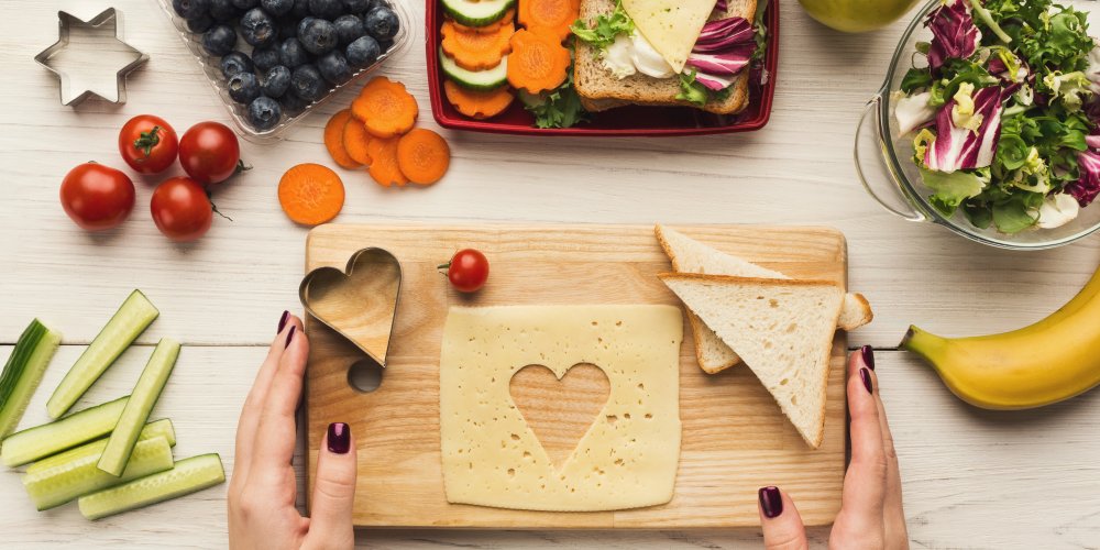 Timber board with cheese and fruit and vegetables surrounding