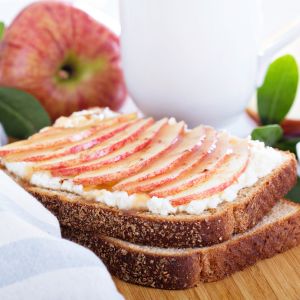 Cottage cheese spread onto wholegrain bread topped with thinly sliced apples