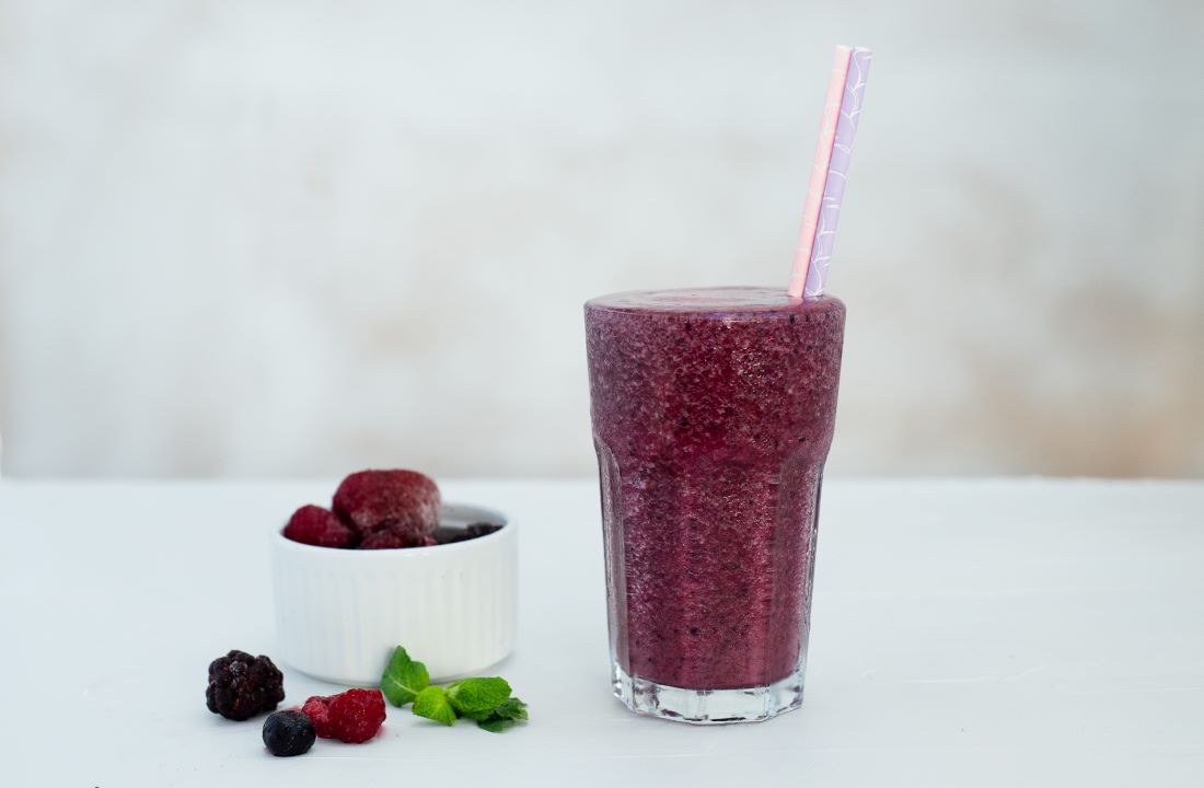 Berry frappe in a glass with a straw