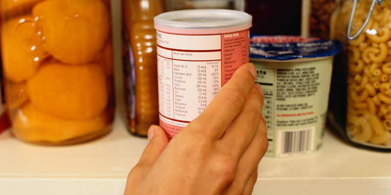 picture of a hand grasping a can of food displaying food label