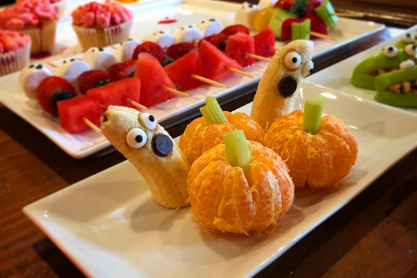 healthy halloween snacks including a mandarin 'pumpkins', banana 'ghost', fruit 'ghoul' kebabs