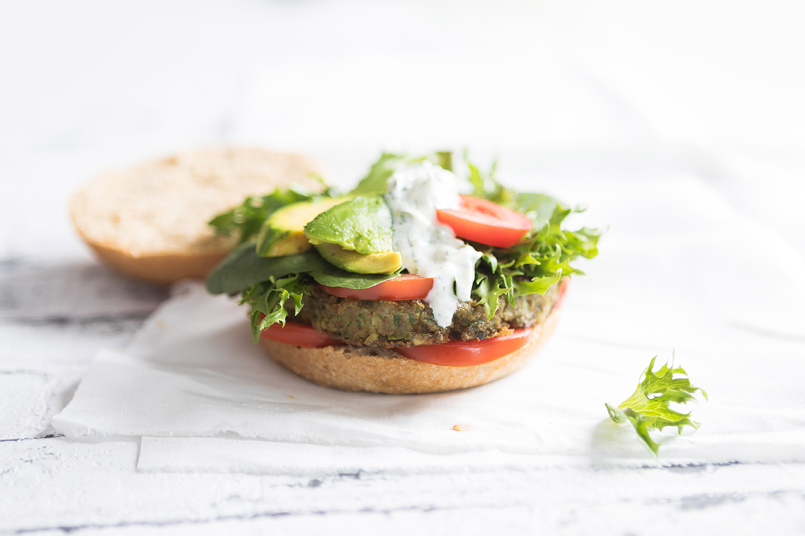 Image of an open lentil burger serving on a white cutting board