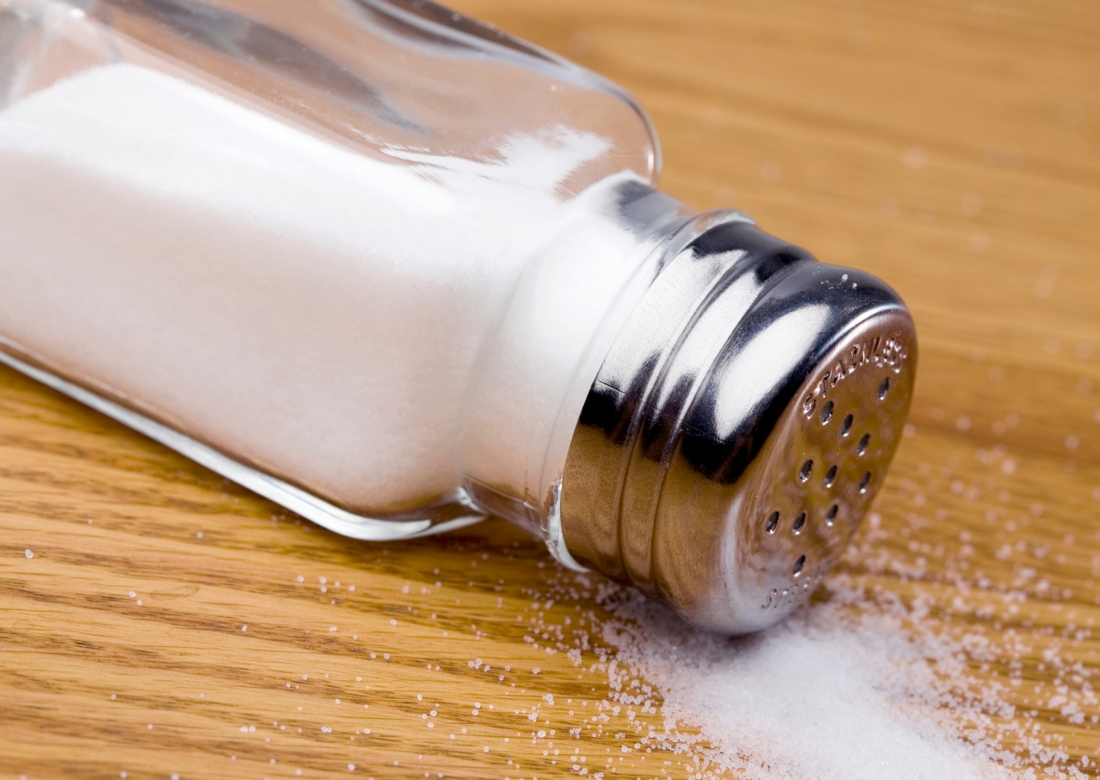 Salt shaker spilling salt onto a table