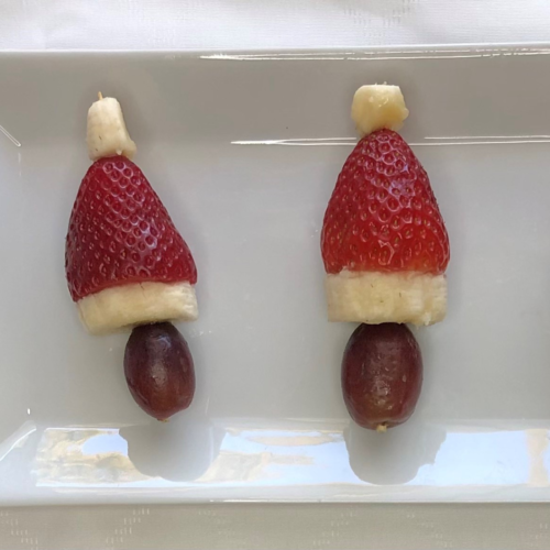 santa hats made from grape, sliced banana and strawberries