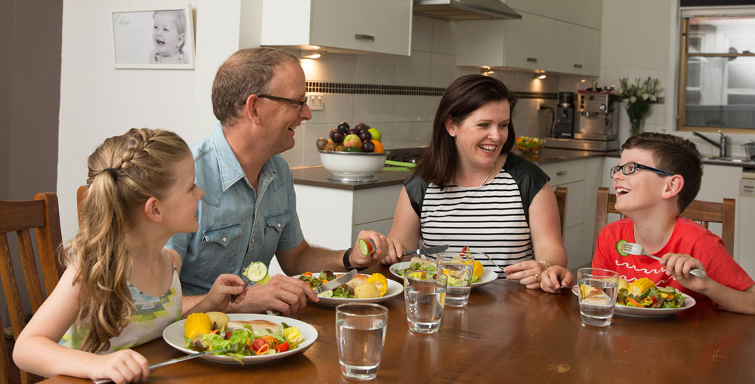 A happy family eating healthy dinner around the table